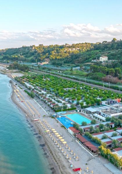 Aerial view of a beach with umbrellas and lush greenery.