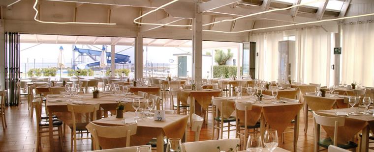 Elegant strandrestaurant, gedekte tafels en heldere sfeer.