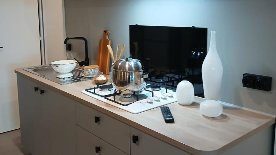 Modern kitchen with stovetop, shelves, and elegant decorations.