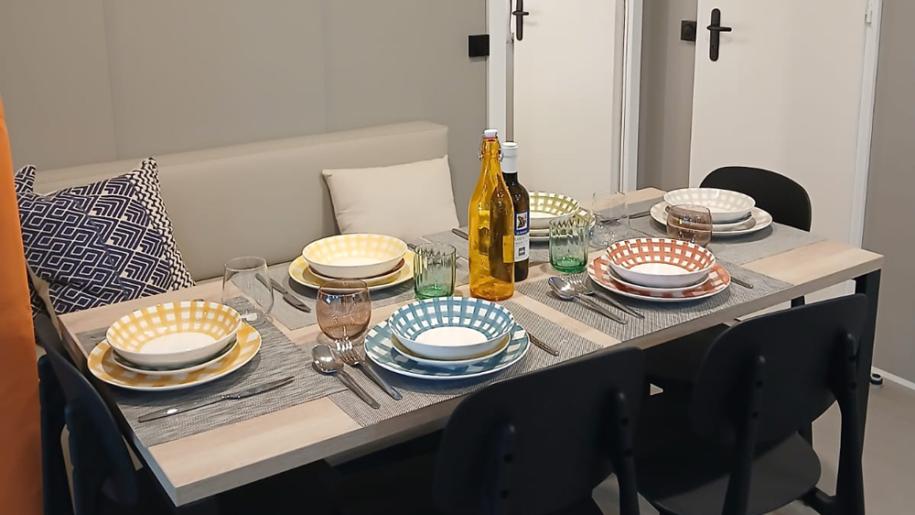 Table set with colorful dishes and bottles.